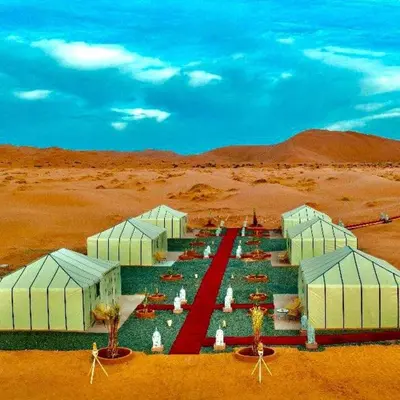 a group of white buildings in the desert at Palmyra Luxury Camp in Merzouga