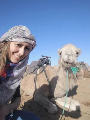 a woman is standing next to a camel at Desert Luxury Tented & Activities in Hassilabied