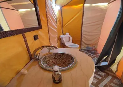 a bathroom with a sink and a toilet in a tent at Desert Luxury Tented & Activities in Hassilabied