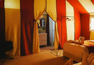 a bedroom with colorful curtains and a bed at Desert Luxury Tented & Activities in Hassilabied