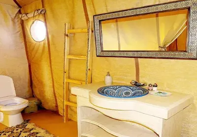 a bathroom with a sink and a mirror and a toilet at Desert Luxury Tented & Activities in Hassilabied