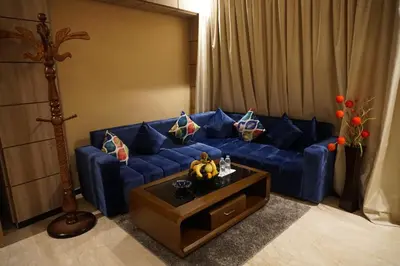 a living room with a blue couch and a table at Hôtel Volubilis Meknès in Meknès