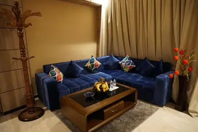 a blue couch in a living room with a table at Hôtel Volubilis Meknès in Meknès