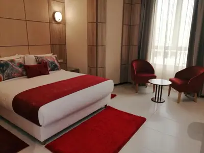 a bedroom with a large bed and a table and chairs at Hôtel Volubilis Meknès in Meknès