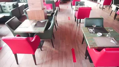 a dining room with red chairs and tables in a restaurant at Hôtel Volubilis Meknès in Meknès