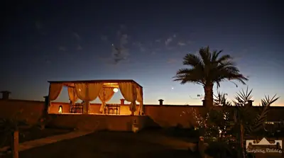 a house lit up at night with a tent at Sunrise Palace Merzouga in Merzouga