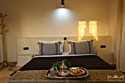 a bedroom with a bed with a tray of food on it at Sunrise Palace Merzouga in Merzouga