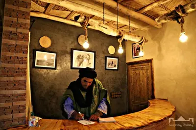 a man sitting at a table in a room at Sunrise Palace Merzouga in Merzouga