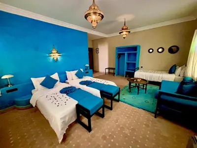 a bedroom with two beds and a blue wall at Dar Morocco in Merzouga