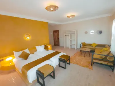 a large bedroom with a large bed and a couch at Dar Morocco in Merzouga