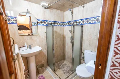a bathroom with a shower and a sink and a toilet at Riad Dar Barae in Fès al Bali