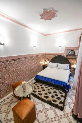 a bedroom with a bed and a table at Riad Dar Barae in Fès al Bali