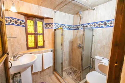 a bathroom with a shower and a toilet and a sink at Riad Dar Barae in Fès al Bali