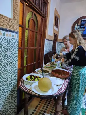 two women sitting at a table with plates of food at Riad Dar Barae in Fès al Bali