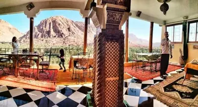 a woman standing in a room with a view of a mountain at Guesthouse Panorama Todra in Tinerhir