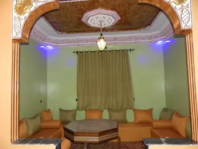 a living room with a couch and a mirror at Luxury Family Apartment in Merzouga