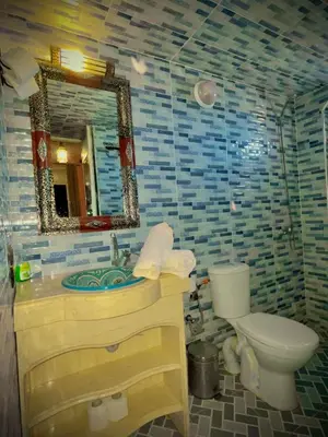 a bathroom with a sink and a toilet and a mirror at Luxury Family Apartment in Merzouga