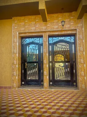 two glass doors on a brick building with a checkered floor at Luxury Family Apartment in Merzouga