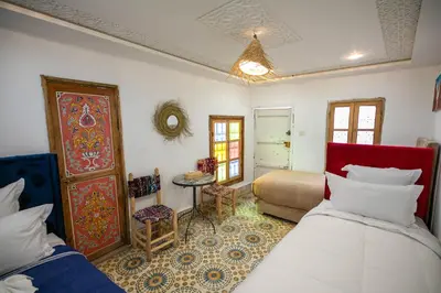 a bedroom with two beds and a table and a table at Riad Moroccan Style in Fès