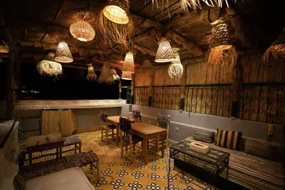 a room with a table and chairs and chandeliers at Riad Moroccan Style in Fès