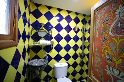 a bathroom with a black and yellow checkered wall at Riad Moroccan Style in Fès