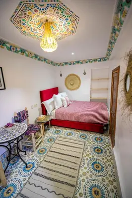 a bedroom with a bed and a table and a rug at Riad Moroccan Style in Fès