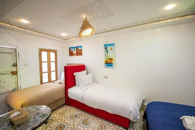 a bedroom with two beds and a table in it at Riad Moroccan Style in Fès