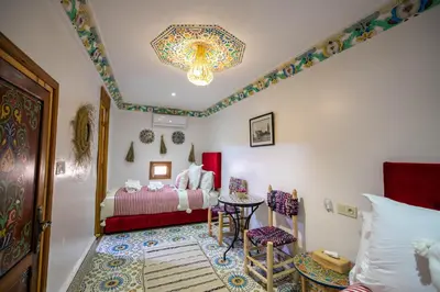 a bedroom with a bed and a table and chairs at Riad Moroccan Style in Fès