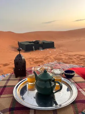 a plate with a teapot on a table in the desert at Nomada Desert Camp in Merzouga