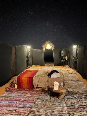 a bedroom with a bed under a starry sky at Nomada Desert Camp in Merzouga