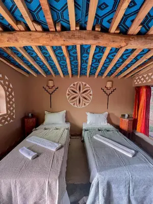 two beds in a room with blue ceilings at Camp Auberge Sahara Marokko in Mhamid
