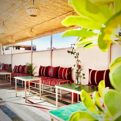 a row of red couches and tables in a room at Riad Dilar Fes & Spa in Fès