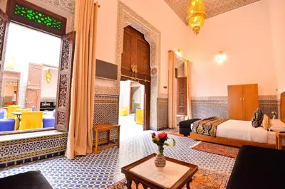 a bedroom with a bed and a table in a room at Riad Dilar Fes & Spa in Fès