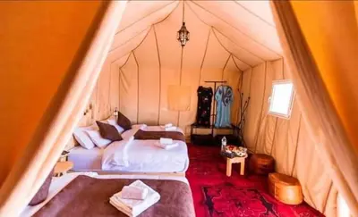a bedroom with a bed in a tent at desert camp sahara luxury in Merzouga