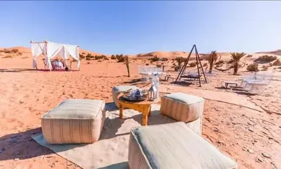 a group of benches and a table in the desert at desert camp sahara luxury in Merzouga