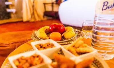 a table with a plate of food and a bowl of fruit at desert camp sahara luxury in Merzouga