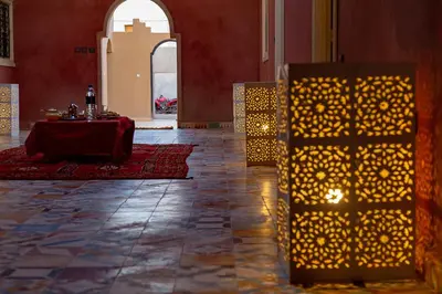 a table in the middle of a room with lights at Dar Oussidi in Merzouga