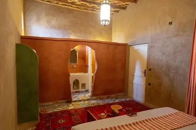 a room with a table and a mirror on the wall at Dar Oussidi in Merzouga