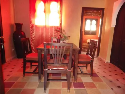a dining room with a wooden table and chairs at Jad Auberge in Ourika