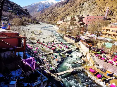 a river with a bunch of umbrellas in a town at Jad Auberge in Ourika