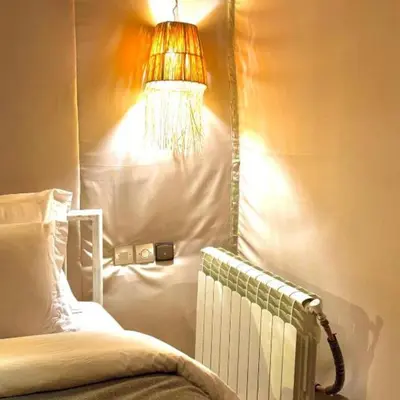 a room with a bed with a lamp and a radiator at Merzouga Horizon Luxury Camp in Merzouga