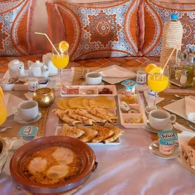 a table with breakfast foods and drinks on it at Merzouga Horizon Luxury Camp in Merzouga