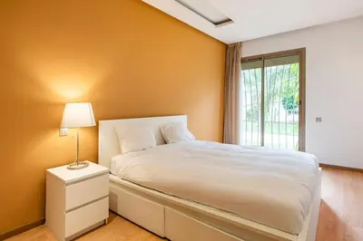 a bedroom with a white bed and a window at Luxury Prestigia Close to Champs de Course Parc in Fès