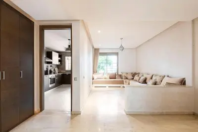 a living room with a couch and a kitchen at Luxury Prestigia Close to Champs de Course Parc in Fès