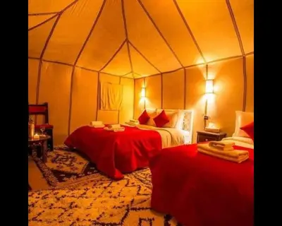 a bedroom with two beds in a tent at Authentique merzouga camp in Merzouga