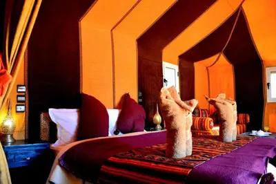 a bedroom with a bed with two stuffed animals on it at Authentique merzouga camp in Merzouga