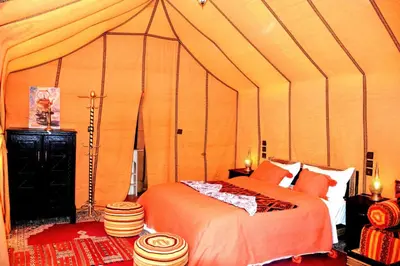 a bedroom with a bed in a tent at Authentique merzouga camp in Merzouga