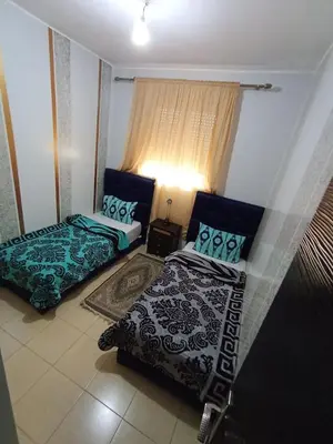 a living room with two beds and a window at Maison Jad in Ifrane