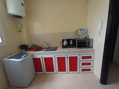 a kitchen with red and white cabinets and a microwave at Maison Jad in Ifrane