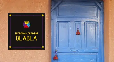a blue door on a building with a sign on it at Auberge Tigida in Mhamid